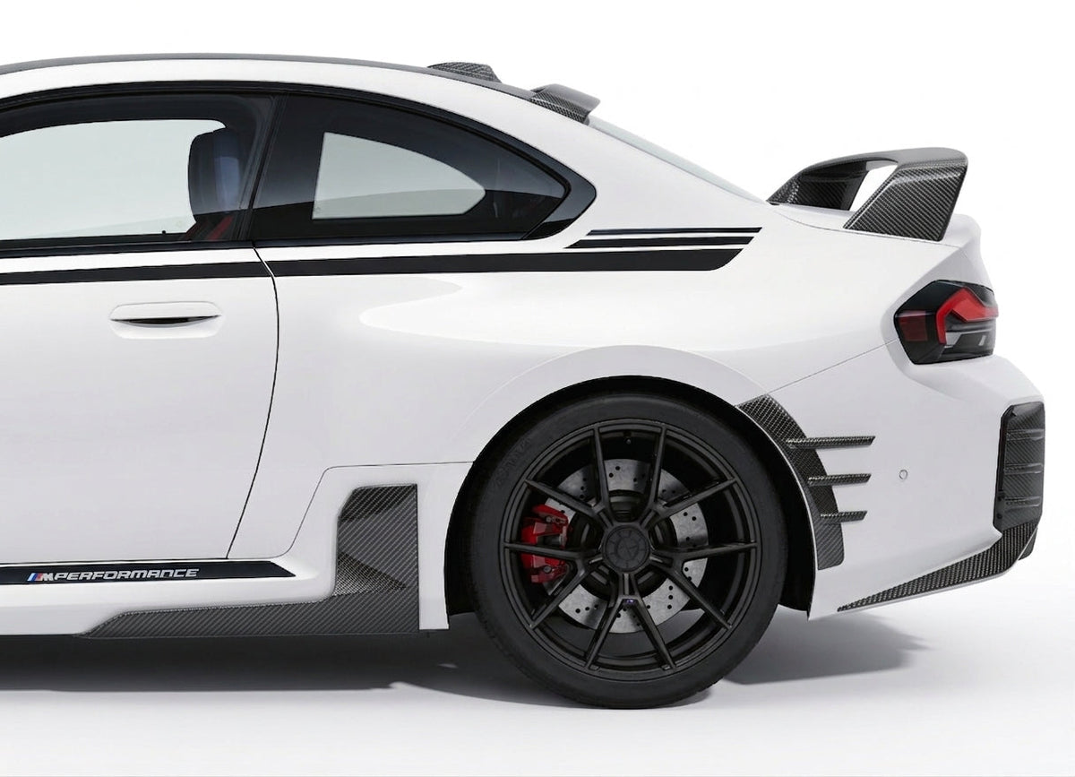 Carbon Corp. carbon fibre side skirt winglets installed on a white BMW M2 G87, showing the rear wheel arch profile.